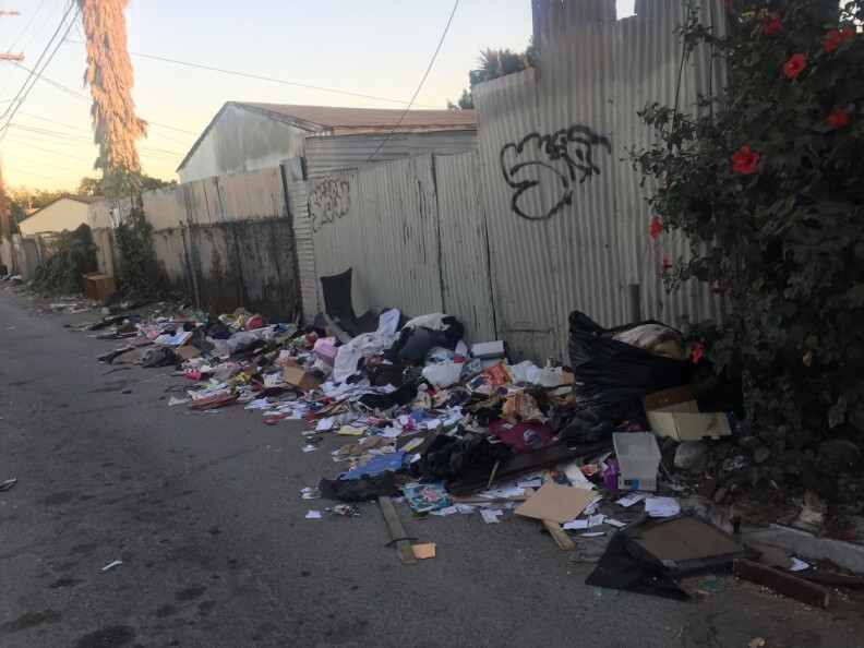 Trash litters a decrepit alley. 