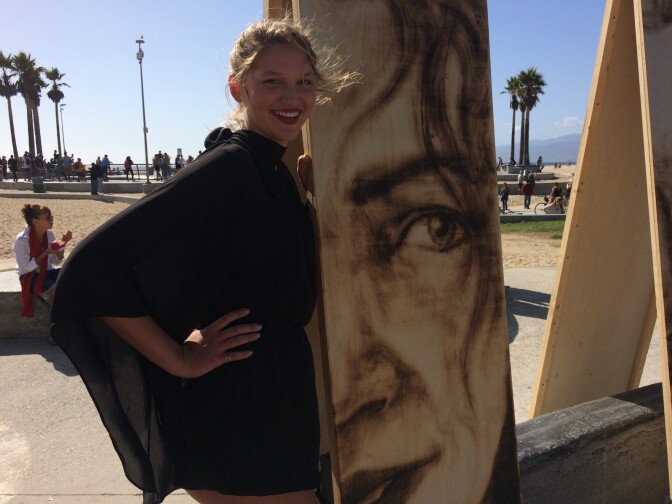 Tazi Apple poses by her finished portrait. It took Aronson around 30-40 minutes to complete. 