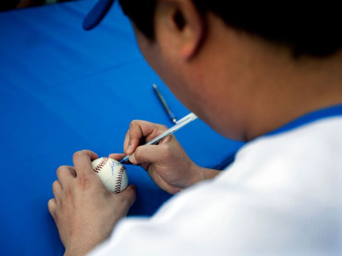 Ryu signs his name with his number, 99. Ryu keeps the same number from his former Korean team.