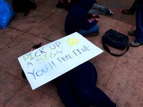 Lollie Reynolds (holding sign) was among dozens of Occupy Riverside protestors rousted from a downtown encampment Wednesday morning. Reynolds and other protestors vowed to return.