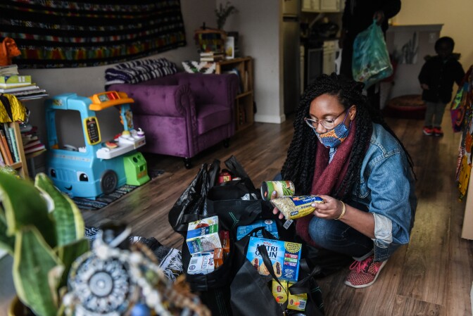 NEW YORK, NY - MAY 11 :   Sevonna Brown of Black Women's Blueprint looks at food and essential items that were delivered to her on May 11, 2020 in the Bedford-Stuyvesant neighborhood in the Brooklyn borough in New York City. Neighborhood mutual aid groups have been cropping up across New York City in an effort to address the economic impact of eight weeks of economic lockdown and the resulting loss of income. Mutual aid provides free food and essential items to communities most in need. Black Woman's Blueprint runs a van called Sistas Van that visits low-income communities of color. (Photo by Stephanie Keith/Getty Images)