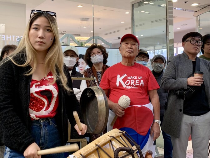 Several South Korea soccer fans watch a giant screen televising the World Cup.