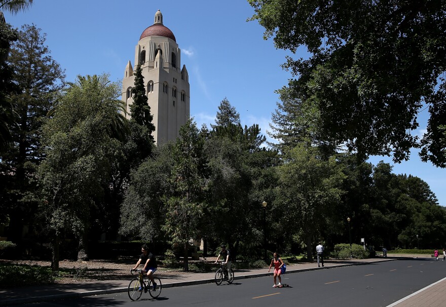 STANFORD, CA - MAY 22:  People ride bikes past Hoover Tower on the Stanford University campus on May 22, 2014 in Stanford, California. According to the Academic Ranking of World Universities by China's Shanghai Jiao Tong University, Stanford University ranked second behind Harvard University as the top universities in the world. UC Berkeley ranked third.  (Photo by Justin Sullivan/Getty Images)