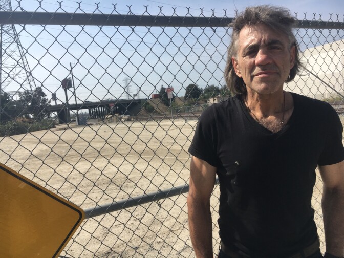 James Russell Stannard, 57, an Air Force veteran, stands by a fence that blocks traffic into a dry ravine in El Monte. He said he's been homeless in the area for about 3 years. Veterans say about 100 homeless people live in the area, where the busy 605 Freeway meets the 10 Freeway.