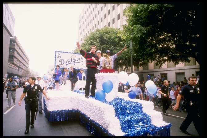 October 1988: Pitcher and World Series MVP Orel Hershiser #55 of the Los Angeles Dodgers waves to the crowd with the World Series Trophy next to him during the Dodgers' victory parade in Los Angeles, California.