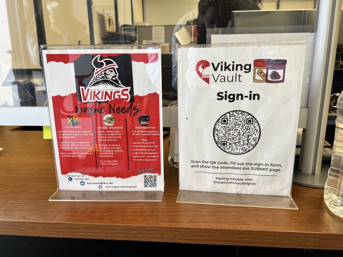 Two small, free-standing posters in red and white with the Viking Vault QR code and other basic needs information.