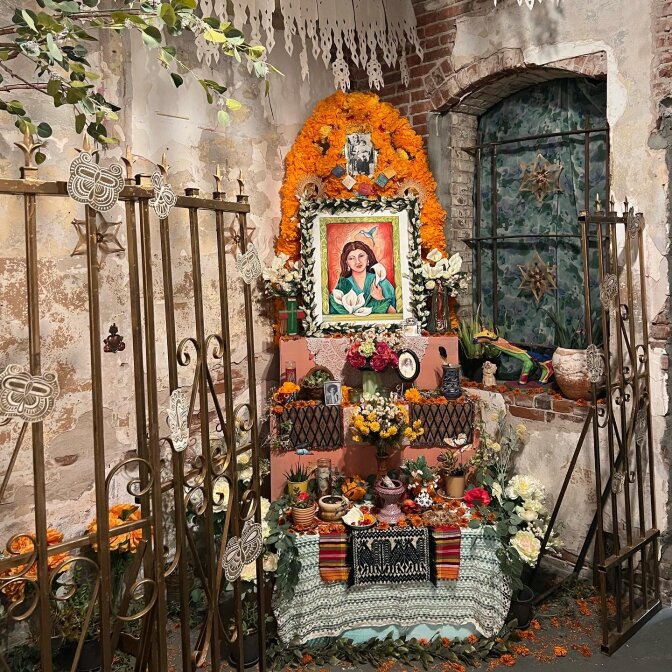A beautifully constructed altar includes photos, marigolds and other offerings