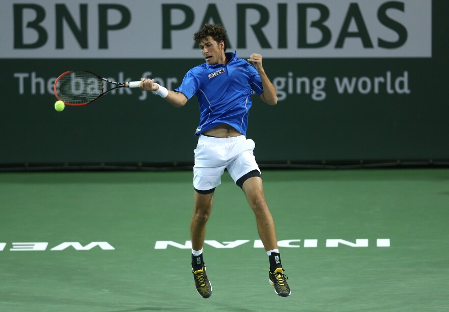Robin Haase of the Netherlands hits a return to Grigor Dimitrov of Bulgaria during the BNP Paribas Open at Indian Wells Tennis Garden on March 9, 2014 in Indian Wells, California.  