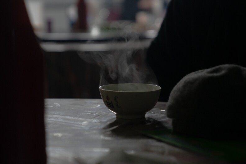 A customer enjoys a cup of hot milk tea at Batdelger Genden's restaurant in Tsagaan Khad.
