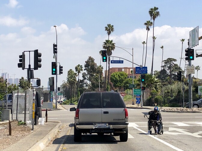 A homeless man begs for change at the Western Ave. exit from the Santa Monica Freeway. (Matt Tinoco/KPCC)