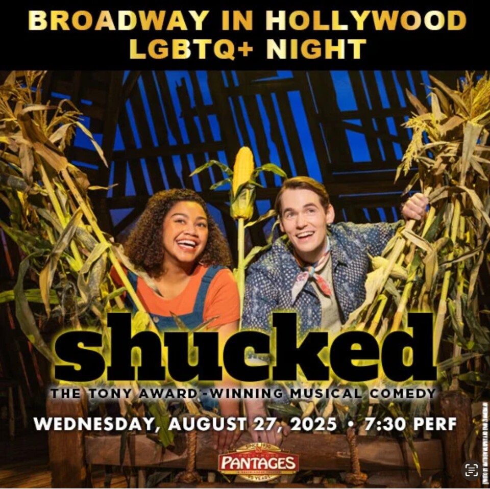 A black woman stands next to a white man between cornstalks.
